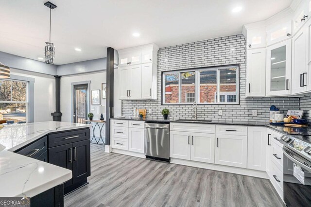 kitchen with appliances with stainless steel finishes, tasteful backsplash, sink, dark stone countertops, and hanging light fixtures