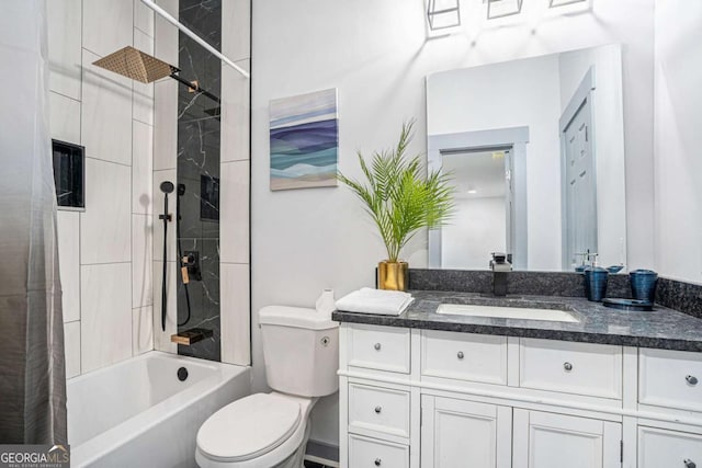 full bathroom with vanity, tiled shower / bath, and toilet