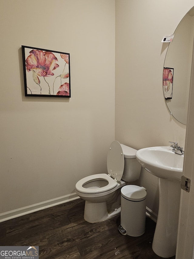 bathroom with hardwood / wood-style flooring, sink, and toilet