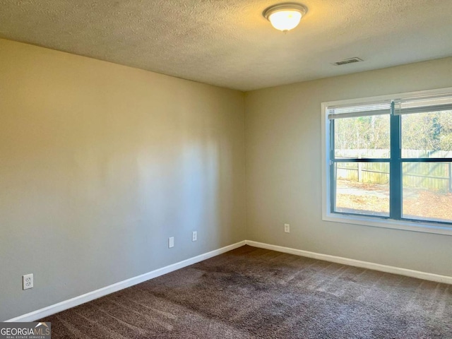 empty room with carpet floors and a textured ceiling