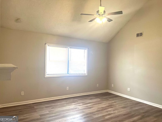 spare room featuring lofted ceiling, dark wood-type flooring, a textured ceiling, and ceiling fan