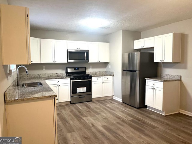 kitchen with sink, dark wood-type flooring, appliances with stainless steel finishes, a textured ceiling, and white cabinets