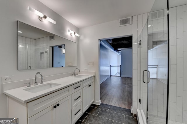 bathroom with walk in shower, vanity, and tile patterned flooring