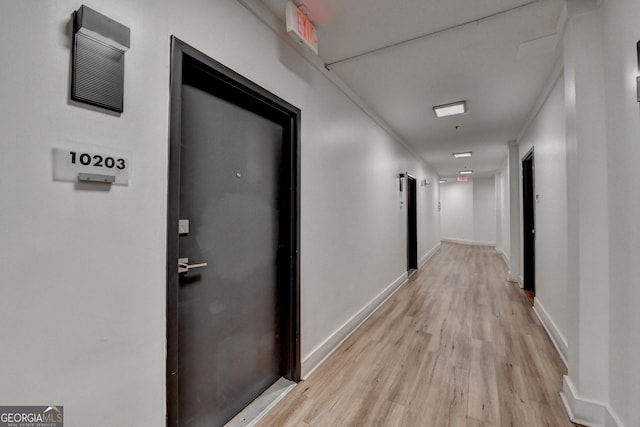 hall with crown molding and light hardwood / wood-style floors