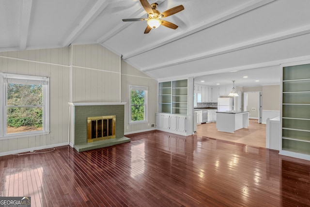 unfurnished living room with ceiling fan, wood-type flooring, a fireplace, and vaulted ceiling with beams