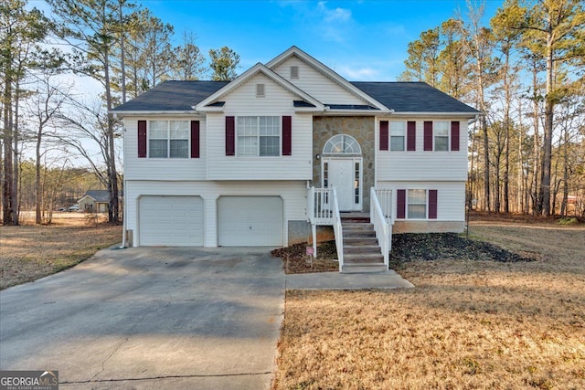 raised ranch with a front lawn and a garage