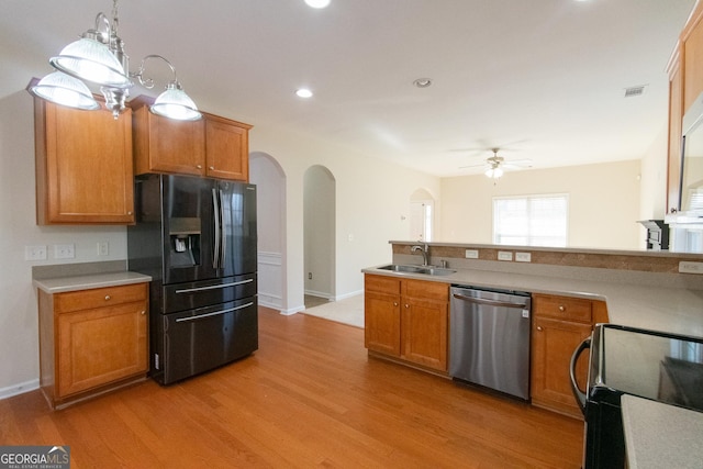 kitchen featuring pendant lighting, sink, light hardwood / wood-style flooring, ceiling fan, and black appliances