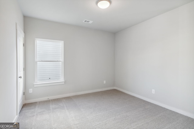 carpeted empty room featuring visible vents and baseboards