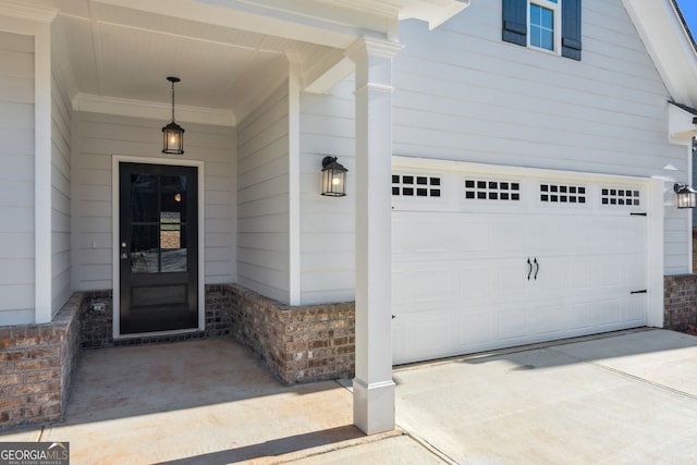 view of exterior entry with driveway and an attached garage