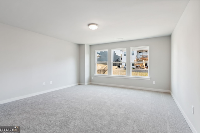 empty room featuring carpet floors and baseboards