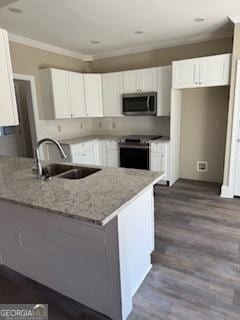 kitchen featuring sink, white cabinetry, ornamental molding, hardwood / wood-style flooring, and stainless steel appliances