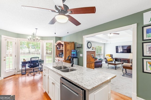 kitchen featuring sink, dishwasher, white cabinetry, an island with sink, and decorative light fixtures