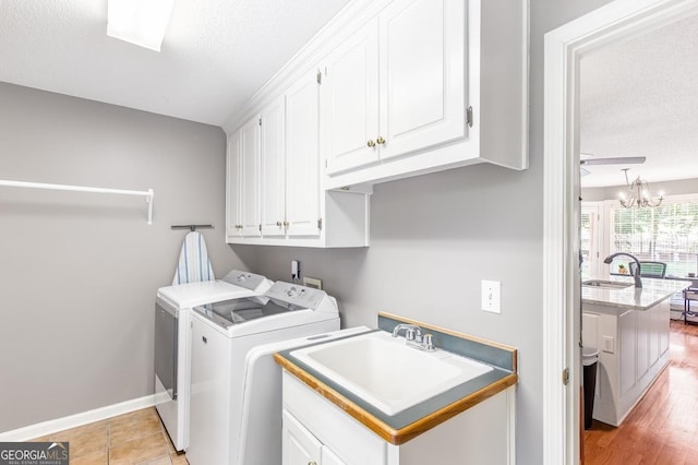 laundry area featuring cabinets, washer and dryer, sink, and a textured ceiling