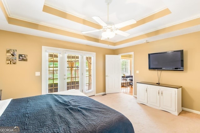 carpeted bedroom with access to outside, a raised ceiling, ceiling fan, and french doors