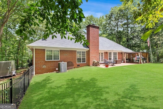 rear view of house with a patio, a yard, and cooling unit