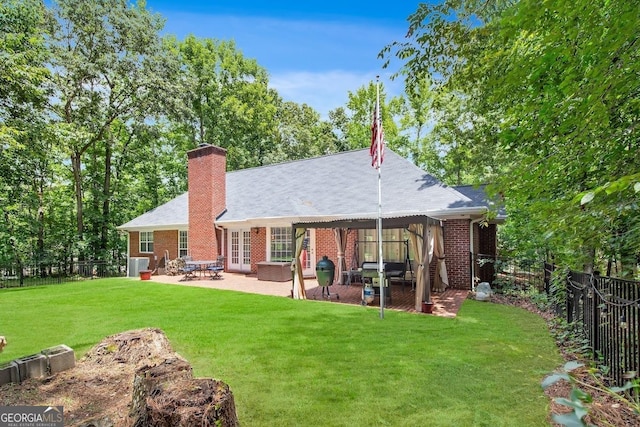 back of property with a yard and a patio