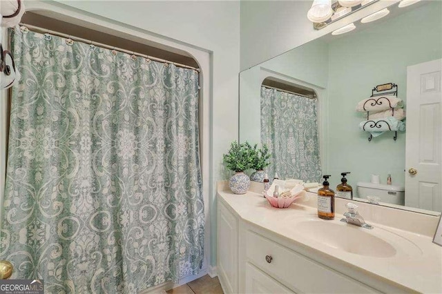 bathroom featuring tile patterned flooring, vanity, and toilet