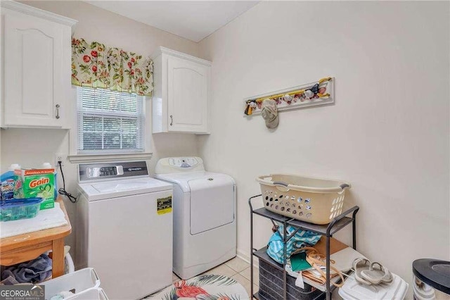 laundry room with cabinets, light tile patterned floors, and washer and clothes dryer