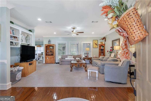 living room featuring crown molding, ceiling fan, and wood-type flooring