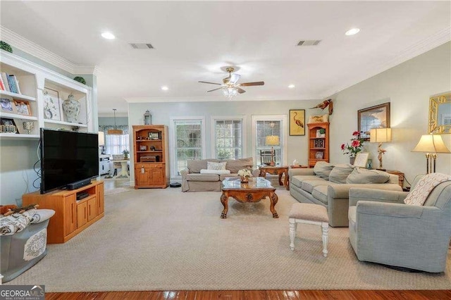 living room featuring light hardwood / wood-style flooring, ornamental molding, and ceiling fan