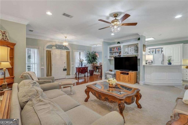 carpeted living room featuring ceiling fan, crown molding, and a healthy amount of sunlight