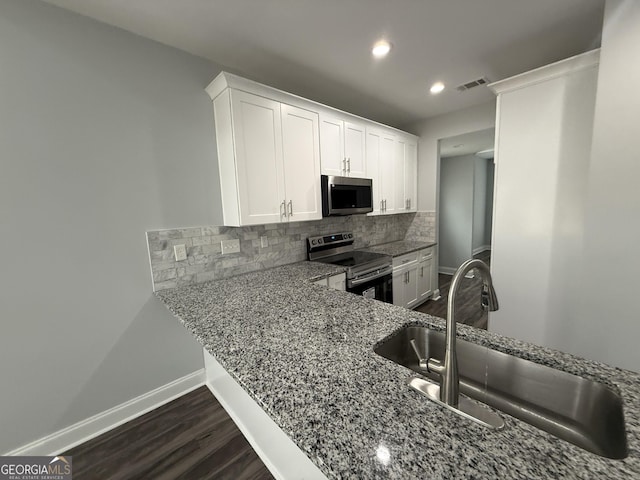 kitchen with light stone counters, sink, stainless steel appliances, and white cabinets