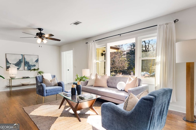 living room with dark wood-type flooring and ceiling fan