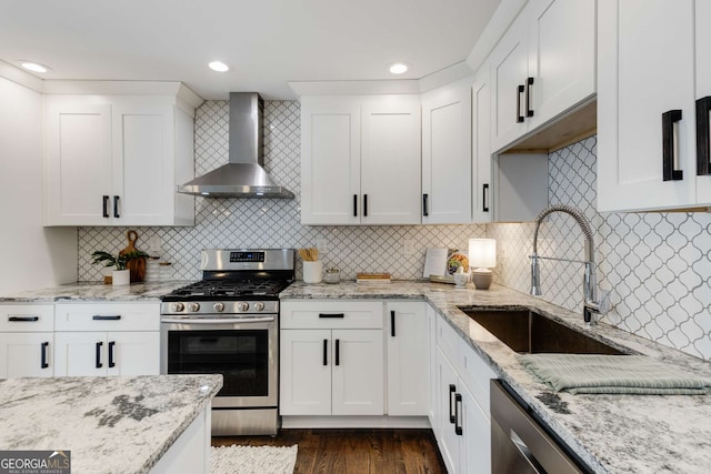 kitchen with wall chimney range hood, backsplash, stainless steel appliances, and sink