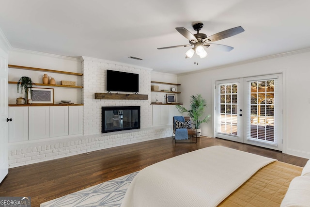 bedroom with hardwood / wood-style flooring, a brick fireplace, access to exterior, and ceiling fan