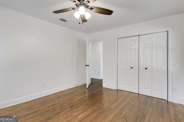 unfurnished bedroom featuring ceiling fan, dark hardwood / wood-style floors, and a closet