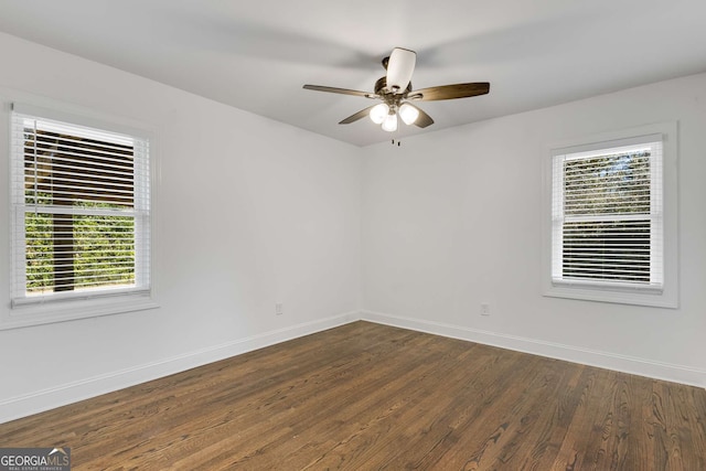 empty room with dark hardwood / wood-style floors and ceiling fan