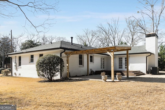 view of front facade featuring french doors, central AC unit, a front lawn, and a patio area