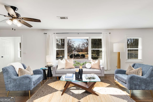 living room with dark wood-type flooring and plenty of natural light