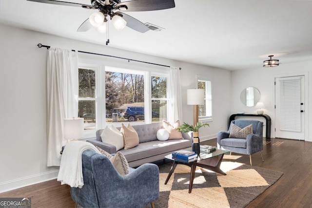 living room featuring dark wood-type flooring and ceiling fan