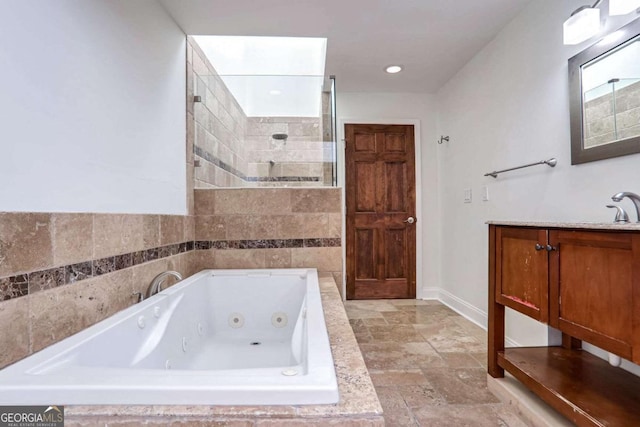 bathroom featuring tiled tub and vanity