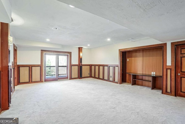 unfurnished room with light carpet and a textured ceiling