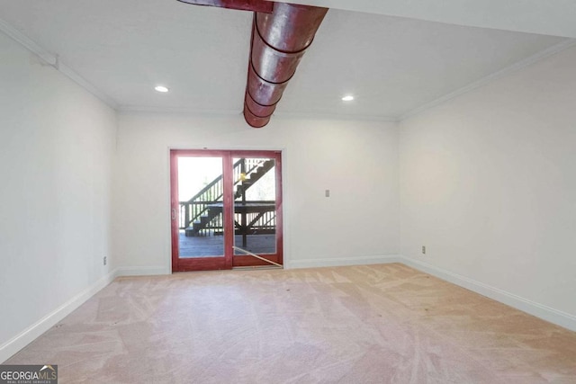 empty room with ornamental molding and light colored carpet