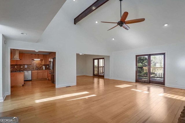 unfurnished living room featuring ceiling fan, beam ceiling, high vaulted ceiling, and light wood-type flooring