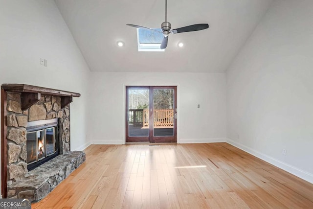 unfurnished living room featuring ceiling fan, high vaulted ceiling, a fireplace, and light hardwood / wood-style floors