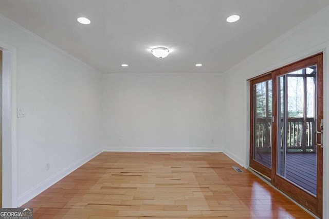 spare room featuring ornamental molding and light wood-type flooring