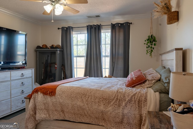 bedroom featuring ornamental molding, visible vents, and a textured ceiling