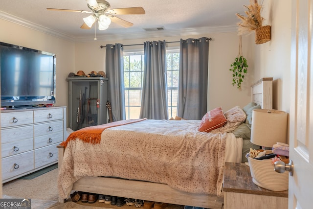 carpeted bedroom featuring ceiling fan, a textured ceiling, visible vents, and crown molding