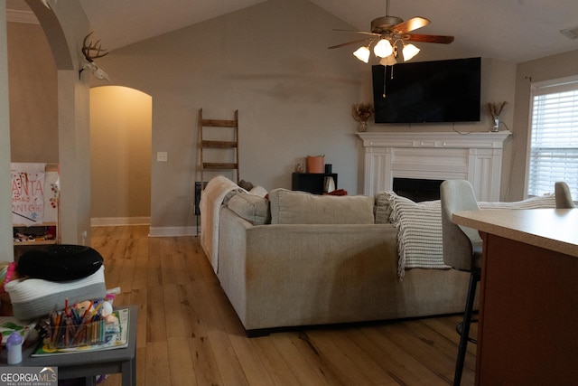 living room with lofted ceiling, light hardwood / wood-style floors, and ceiling fan