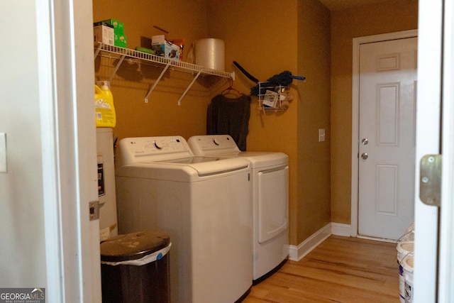 laundry room featuring light wood-type flooring and washer and clothes dryer