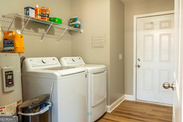 laundry room featuring gas water heater, wood finished floors, washer and dryer, laundry area, and baseboards