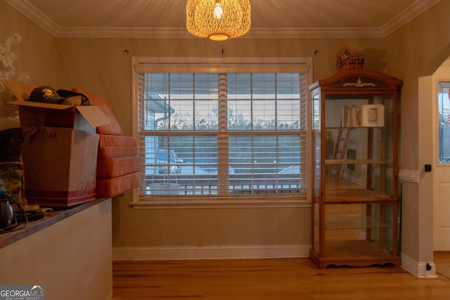 dining space featuring ornamental molding, a healthy amount of sunlight, and wood-type flooring