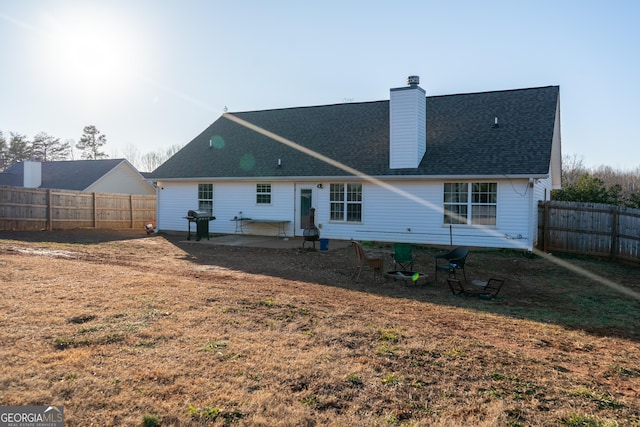 back of house featuring a shingled roof, a patio, a chimney, and fence