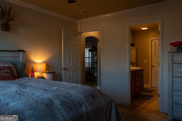 bedroom featuring ceiling fan, ensuite bath, and ornamental molding