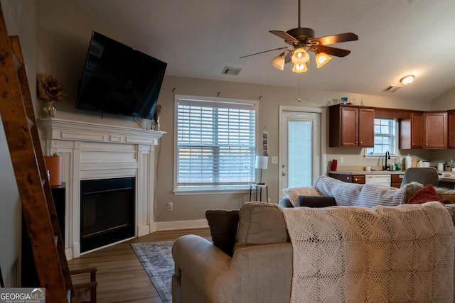 living room featuring ceiling fan, plenty of natural light, lofted ceiling, and dark hardwood / wood-style flooring