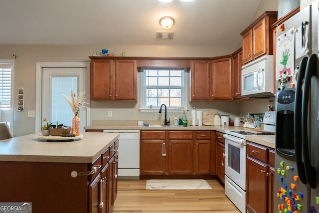 kitchen with white appliances, sink, and light wood-type flooring